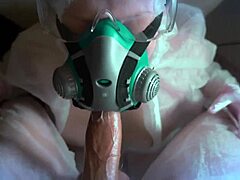 Момиче с маска, облечено в защитен костюм и противогазна маска, прави орален секс по време на епидемията на COVID-19
