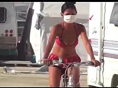 Barefoot Latina girl on bike rides beach in bareback style