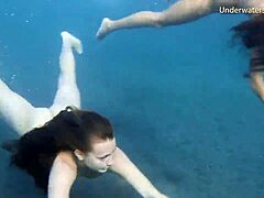 Una ragazza dai capelli rossi e una ragazza bionda esplorano i corpi l'una dell'altra in piscina