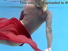Emily Ross, een blonde milf, kleedt zich uit in het zwembad