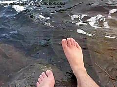 Mikas store og hårete føtter nyter barfotlek i vannet