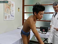 Зряла лекарка извършва анален преглед на кльощаво азиатско момче, преди да се включи в сексуална активност